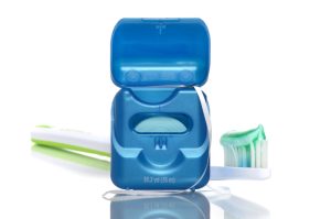 Floss and a toothbrush behind it