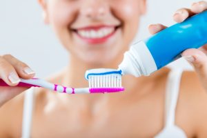 Woman putting toothpaste on a toothbrush