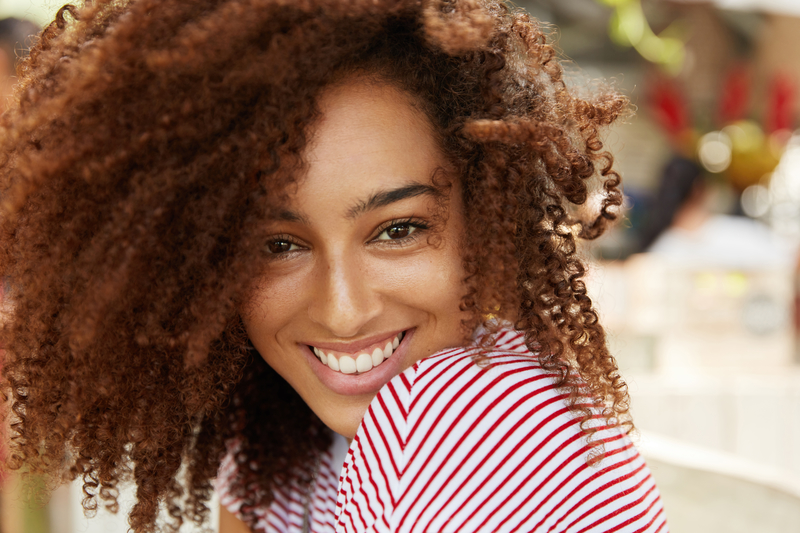 Young African American female smiling at the camera.