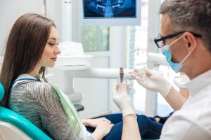 Dentist explaining a dental implant to a patient