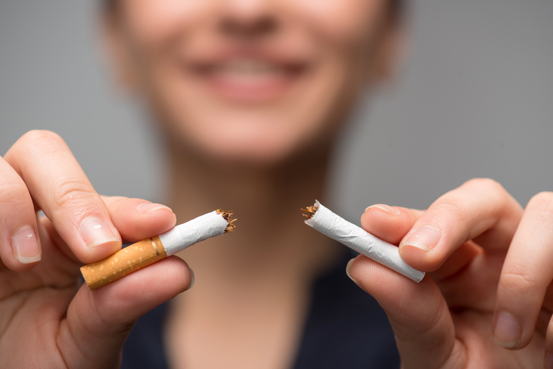 Close up of a young woman breaking apart a cigarette.