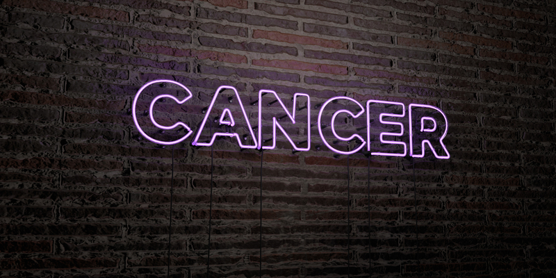 Neon pink sign on a brick backdrop.